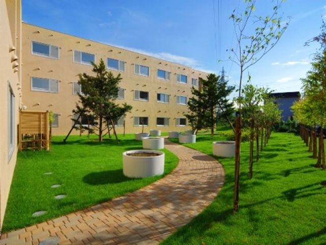 中庭の緑豊かな景観 中庭 陽光あふれる中庭では、新緑を眺めながらの散歩が気持ちの良い空間を提供しています。ゆったりとした時間を過ごせる場所です。