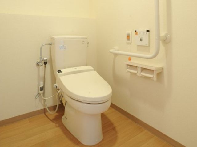 車椅子対応のトイレ トイレ 手すり付きで安全なトイレ空間です。利用者が自立した日常生活を送るための配慮がされています。