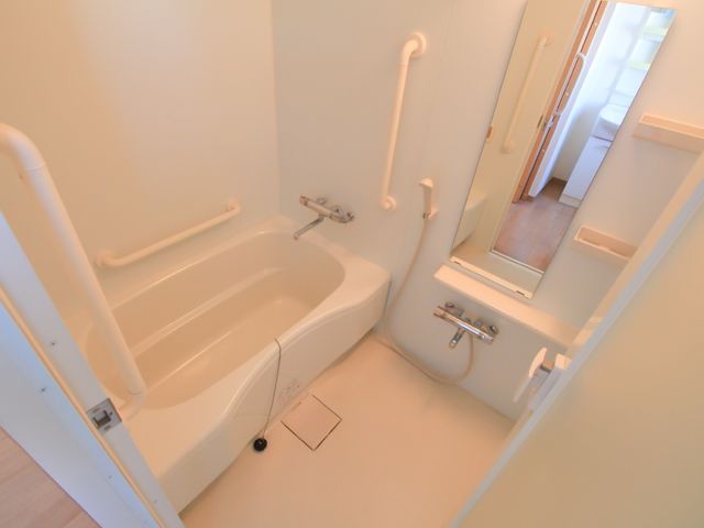 手すり付きのバスルーム 浴室 手すりが多数設置された清潔感のある浴室です。安全に配慮された設計で、利用者の方々の快適な入浴を支えます。