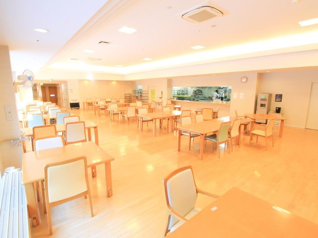 明るい広々とした食堂 食堂 ゆったりとした座席配置で、日々の食事を穏やかな時間としてお過ごしいただける空間です。キッチンが近く、温かい料理がすぐに提供できる造りになっています。