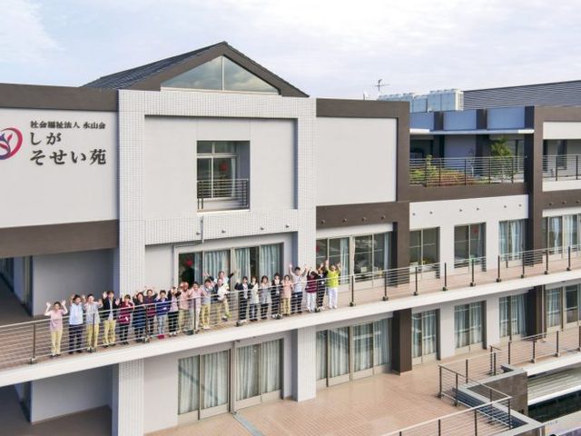 様々な人が立つ外観 外観 様々な方が立っている、開放感のある建物の外観です。広々としたバルコニーがあり、居心地の良さを感じさせます。
