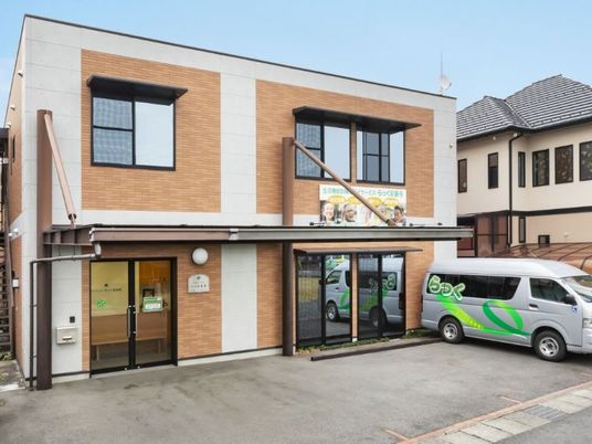 明るい外観と送迎車の建物  
