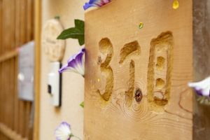 部屋番号が彫られた木製の表札