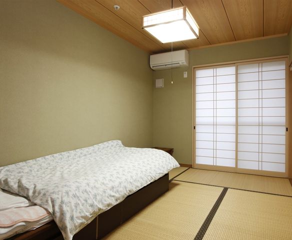 居心地の良い和室 居室 落ち着いた色合いの和室は、布団が敷かれ快適にお休みいただける空間です。明るい雰囲気の中でリラックスしていただけることでしょう。