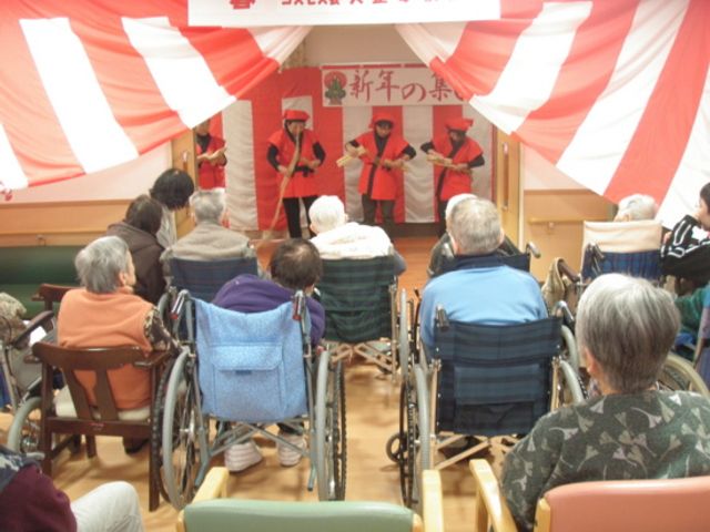 新年のイベント参加者 多目的室 新年を祝い、椅子や車椅子の方々が楽しんでいるイベントの様子です。交流を深める機会です。