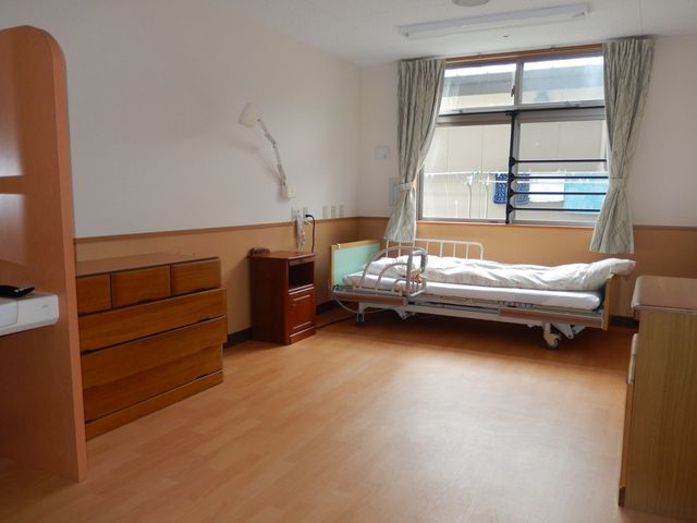 窓際のベッド部屋 居室 大きな窓から自然光が入る明るい居室です。快適な休息ができる配置になっています。