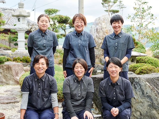庭にいるスタッフ 庭 和やかな雰囲気の中で、スタッフが庭にいます。自然に囲まれた職場環境が魅力です。