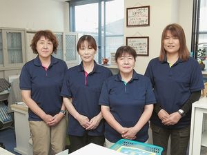 スタッフが並ぶ事務室  