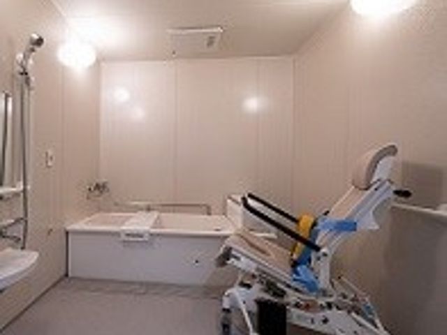明るいバスルーム 浴室 広々とした設備が整い、介護をサポートする機器が設置された明るい空間です。