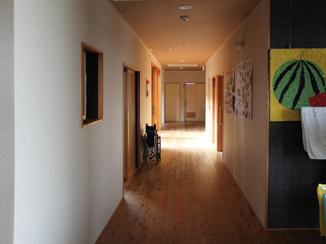 木の温もりを感じる廊下 廊下 木の床材が使われた明るい廊下です。壁には色鮮やかな作品が飾られています。