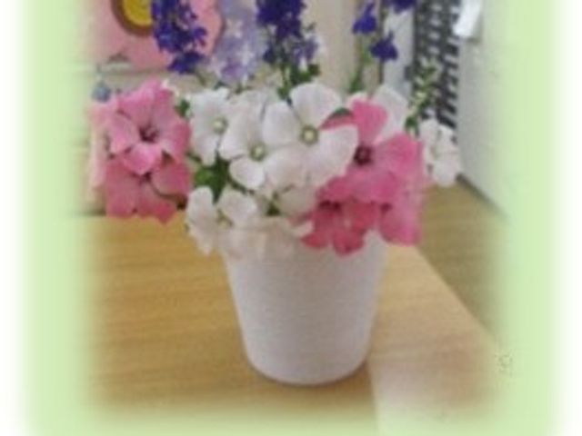 花の鉢が置かれた室内 ロビー   花の鉢がテーブルに置かれ、やわらかな雰囲気の空間です。落ち着いた印象で、来訪者を迎える場として見やすいです。