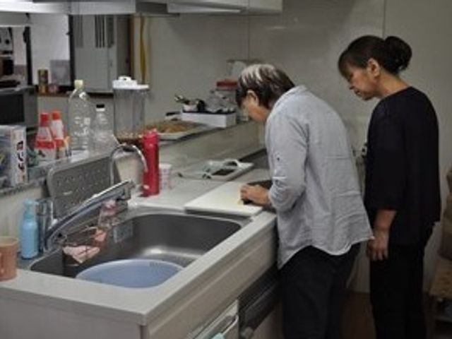 キッチンで作業する人々 リハビリ 共用キッチンで、利用者と一緒に料理の準備をする職員の姿です。日常生活に寄り添った支援が行われています。