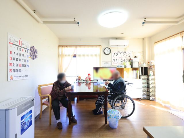 共有スペースでの憩い時 リビング ゆったりとした時間が流れる共有スペースで、利用者同士が穏やかなひとときを過ごしています。明るく開放的なこの場所は、居心地の良さも魅力の一つです。