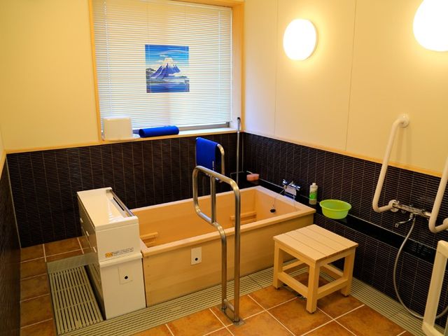 快適な浴室 浴室 木製の浴槽が魅力の落ち着いた空間です。手すりが設置され、安全に利用できます。