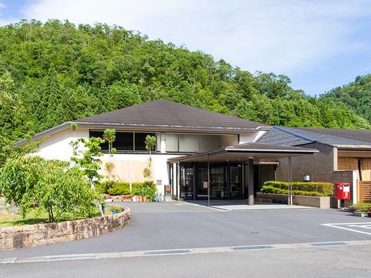緑に囲まれた施設の外観  