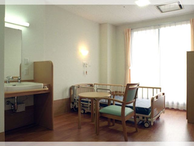 明るい部屋　居室 居室 広々とした明るい居室で、窓から自然光が差し込みます。ベッドとチェアが配置されています。
