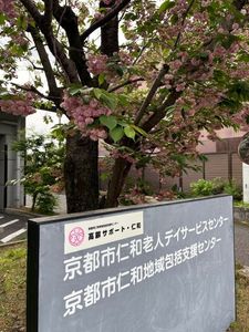 看板と桜のある外観  
