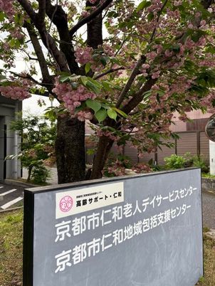 看板と桜のある外観  