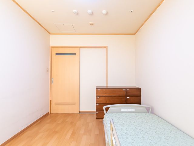 ベッドのある居室 居室 シンプルで落ち着いた空間が広がっており、家具の配置が効率的です。