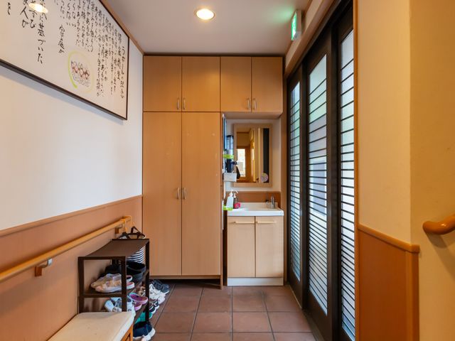 玄関空間 エントランス 自然光が差し込み、温かみのあるデザインが施された入口です。靴の収納スペースも整っています。