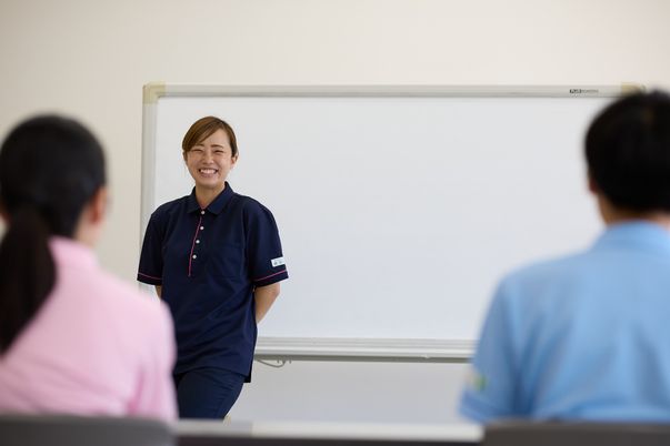 笑顔のスタッフとホワイトボードでの研修風景
