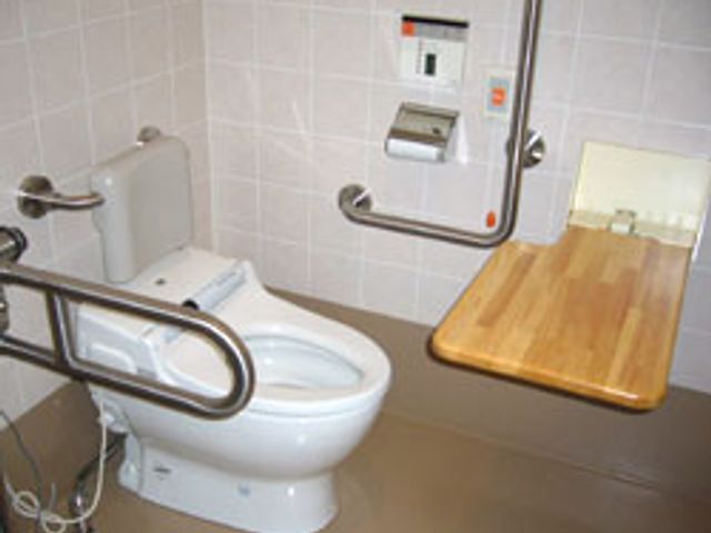 手すりが付いた便器 トイレ 広々とした明るい空間で、手すりが設置されており安全に配慮されています。清潔で安心してご利用いただけます。