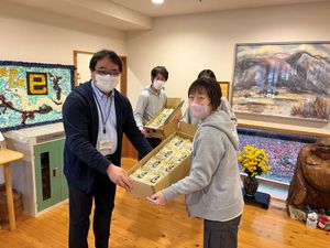 リビングで箱を受け渡す場面  