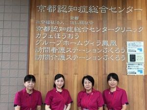 スタッフが並ぶ掲示壁前  