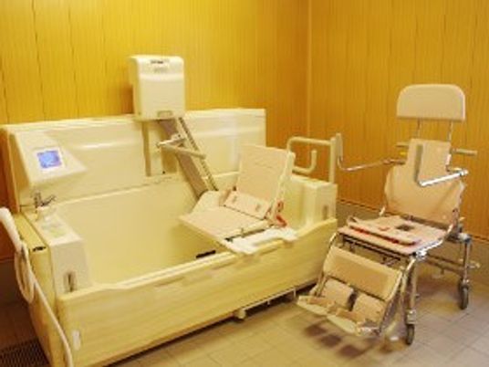木目調の浴室には介護度が高い人のための機械浴が置かれている。
