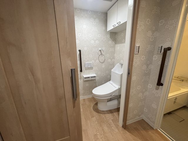 清潔な洗面台とトイレ トイレ 落ち着いたデザインで、清潔感が溢れるトイレです。高齢者にも優しい手すりが備え付けられています。