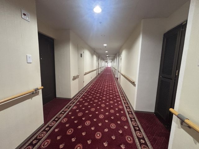 奥行きのある廊下 廊下 両側に手すりが設置され、安全に移動できる長い廊下です。清潔で落ち着いた雰囲気があります。