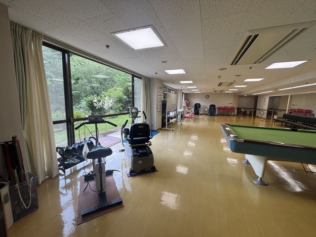 運動器具のある広い部屋 機能訓練室 自然光が差し込む空間で、リハビリをサポートする設備があります。広々として快適に利用できます。