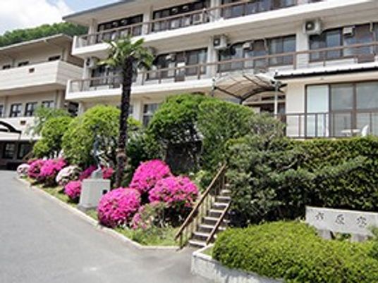 緑に囲まれた建物の外観  