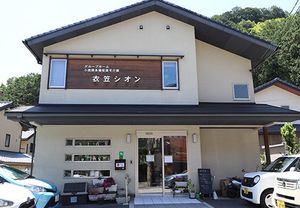 木の看板がかかる外観