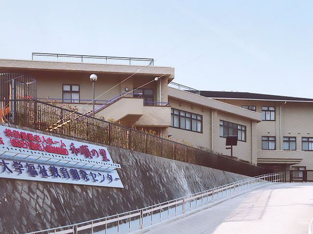 大きな建物と看板 看板 こちらの施設は、見晴らしの良い高台に位置しています。訪れた際には立派な看板が目印です。