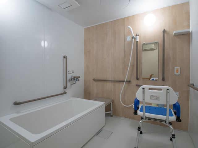 バリアフリー設計の浴室 個人用風呂 安全に配慮された設備が整った浴室です。手すりや座面を備えた入浴補助椅子があり、快適にご利用いただけます。