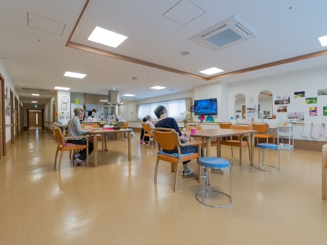 広々とした明るい食堂 リビングダイニング3 日差しの優しい光が差し込む食堂です。利用者が落ち着いて食事を楽しんでいる様子が伺えます。