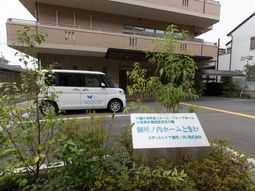 施設前の看板と送迎車