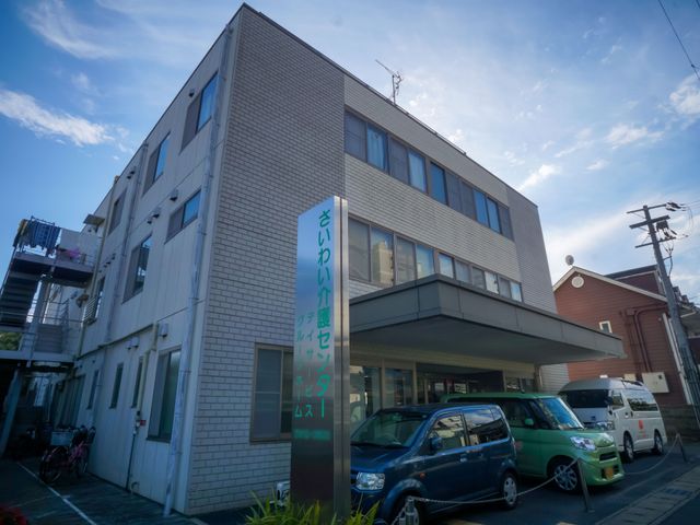 建物外観と看板 外観 清潔感のある建物前には、利用者の方々が利用されている様子が見て取れます。働く環境も整っており、就業に適しています。