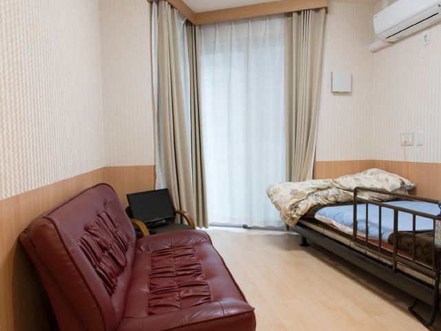 快適な居室の一例 部屋 手入れが行き届いた居室です。ゆったりしたソファとベッドが設置され、快適な日々を過ごせる環境が整っています。