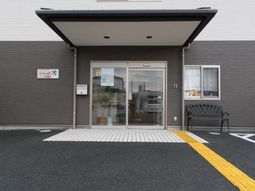 玄関とベンチのある施設外観