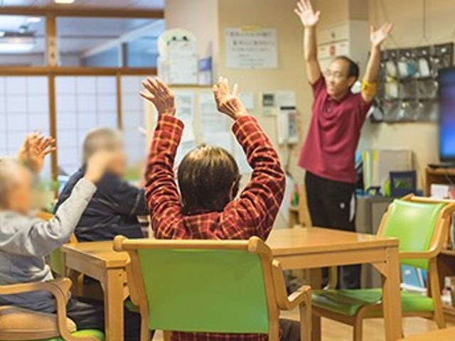 体操を楽しむ様子の場所 多目的室 自然光が豊富に差し込む明るい空間です。高齢者が集い、体操を楽しむ和やかなひとときがあります。