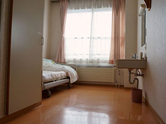 居室のベッドと洗面台 居室   明るい窓辺にベッドが配置された、落ち着いた個室です。洗面台も備わっており、身支度がしやすそうです。