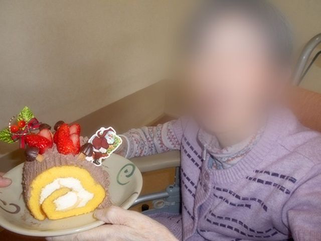 車椅子の方の様子 リビング 車椅子に座った方がくつろぐ場面です。安心して過ごせる暖かい交流の場です。