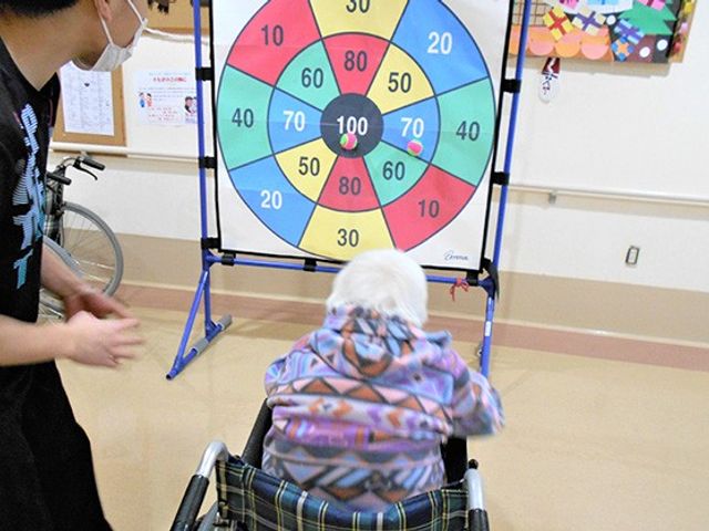 ダーツを楽しむ様子 多目的室 車椅子でも参加できるダーツのアクティビティが行われています。