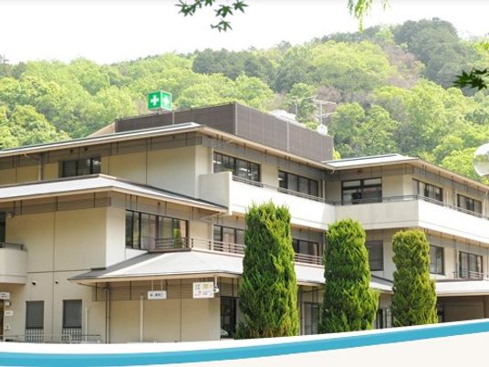 緑に囲まれた建物の外観  