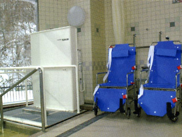 車椅子とエレベーター 浴室 自然光が差し込む明るい空間で、車椅子利用者に配慮した設備が整っています。助けを必要とする方に安心感を提供します。