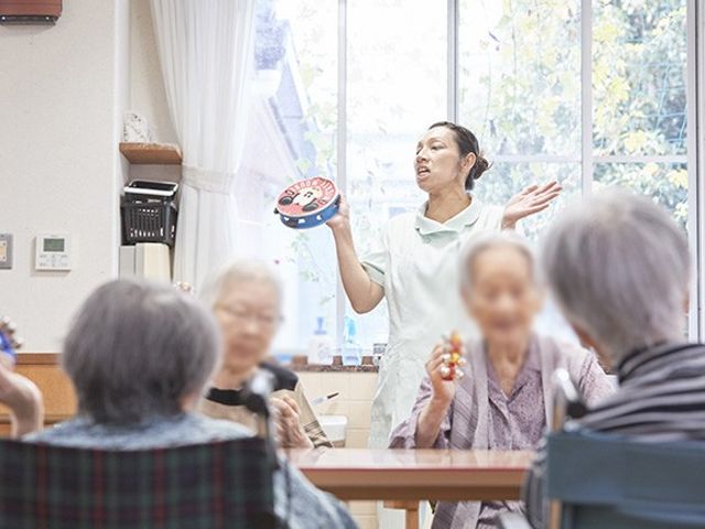 集いの広間 リビング 自然光が差し込む広々とした空間で、皆さんが談笑を楽しんでいます。リラックスしながら過ごせる場所です。