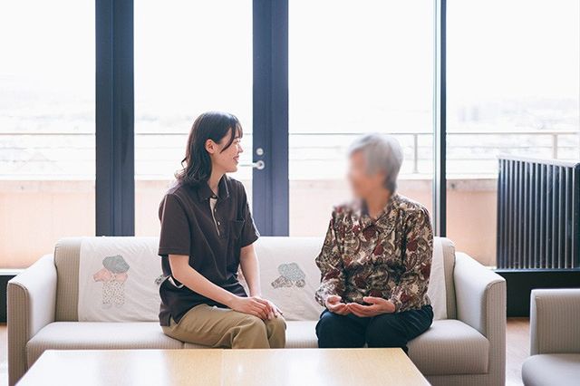 明るい談話室 ラウンジ 広々としたラウンジで、スタッフと利用者がリラックスして会話を楽しんでいます。