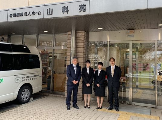 制服姿の職員が並ぶ玄関  